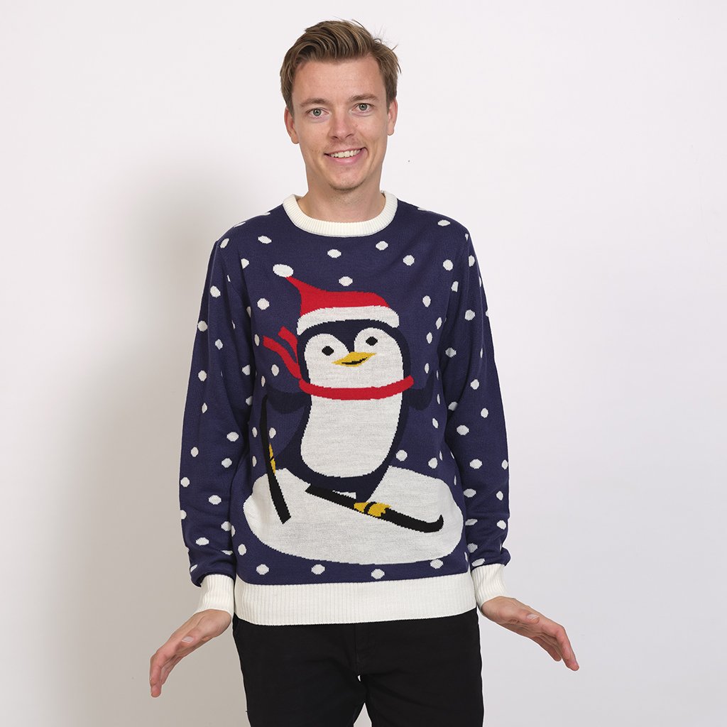 En man i en blå jultröja med en pingvin på.